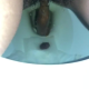 From under the toilet, a very cute girl mostly pees with light product. Poop action limited. Brief clip. Filmed from a between the legs perspective. Vertical format video. Under a minute.